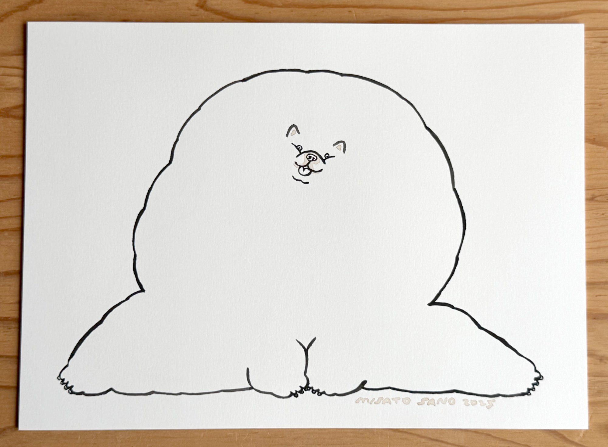 Simple black line drawing of a dog on a white sheet of paper, placed on a wooden surface.