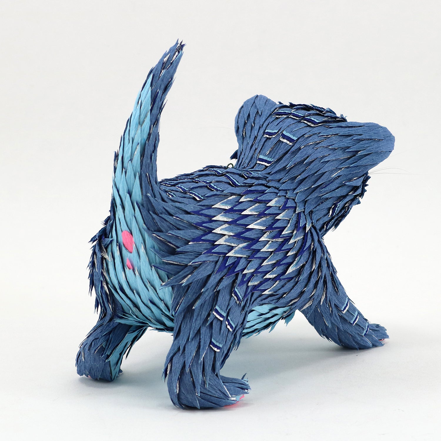 Blue textured sculpture of a creature on a white background