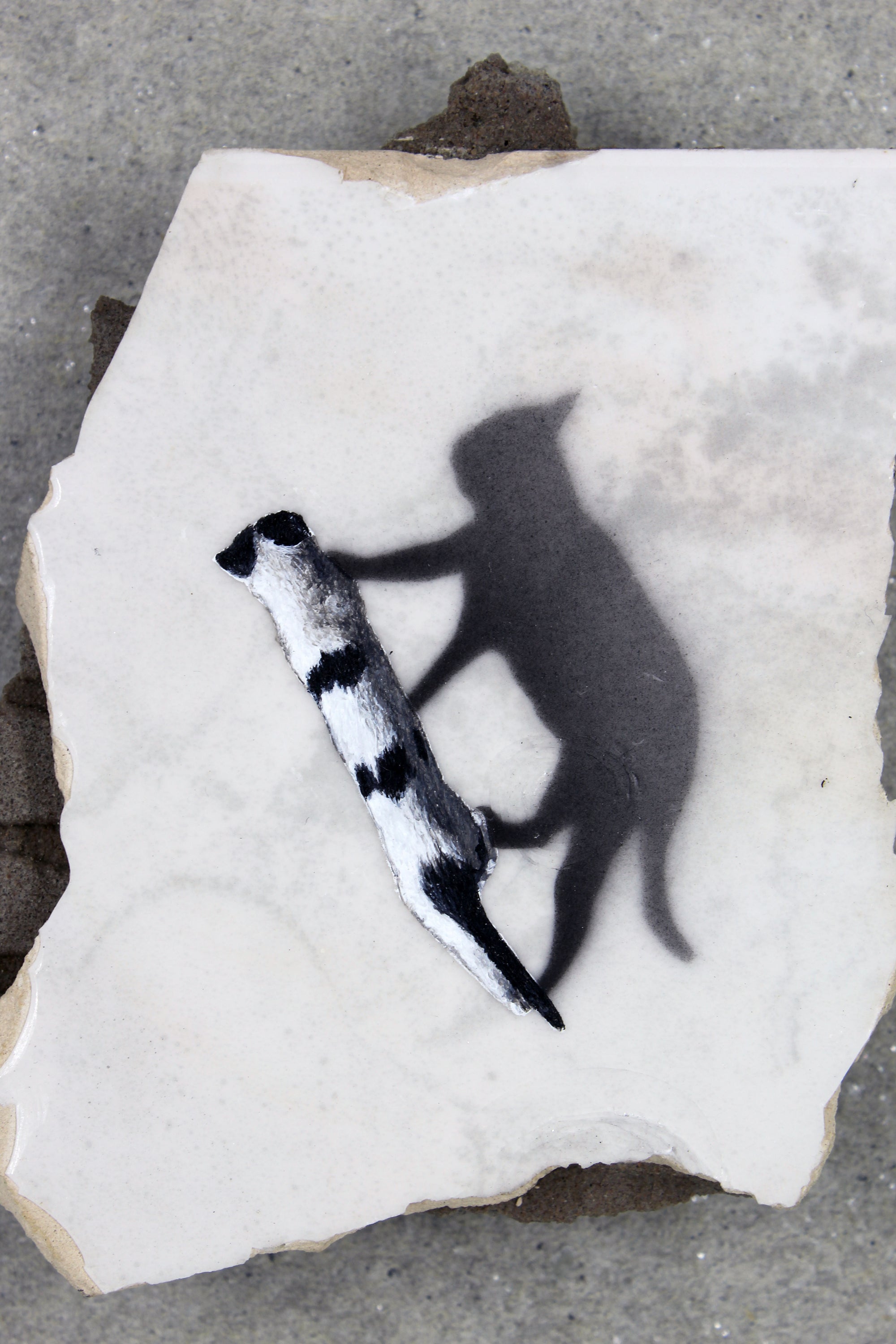 a cat painting with its shadow on piece of tile