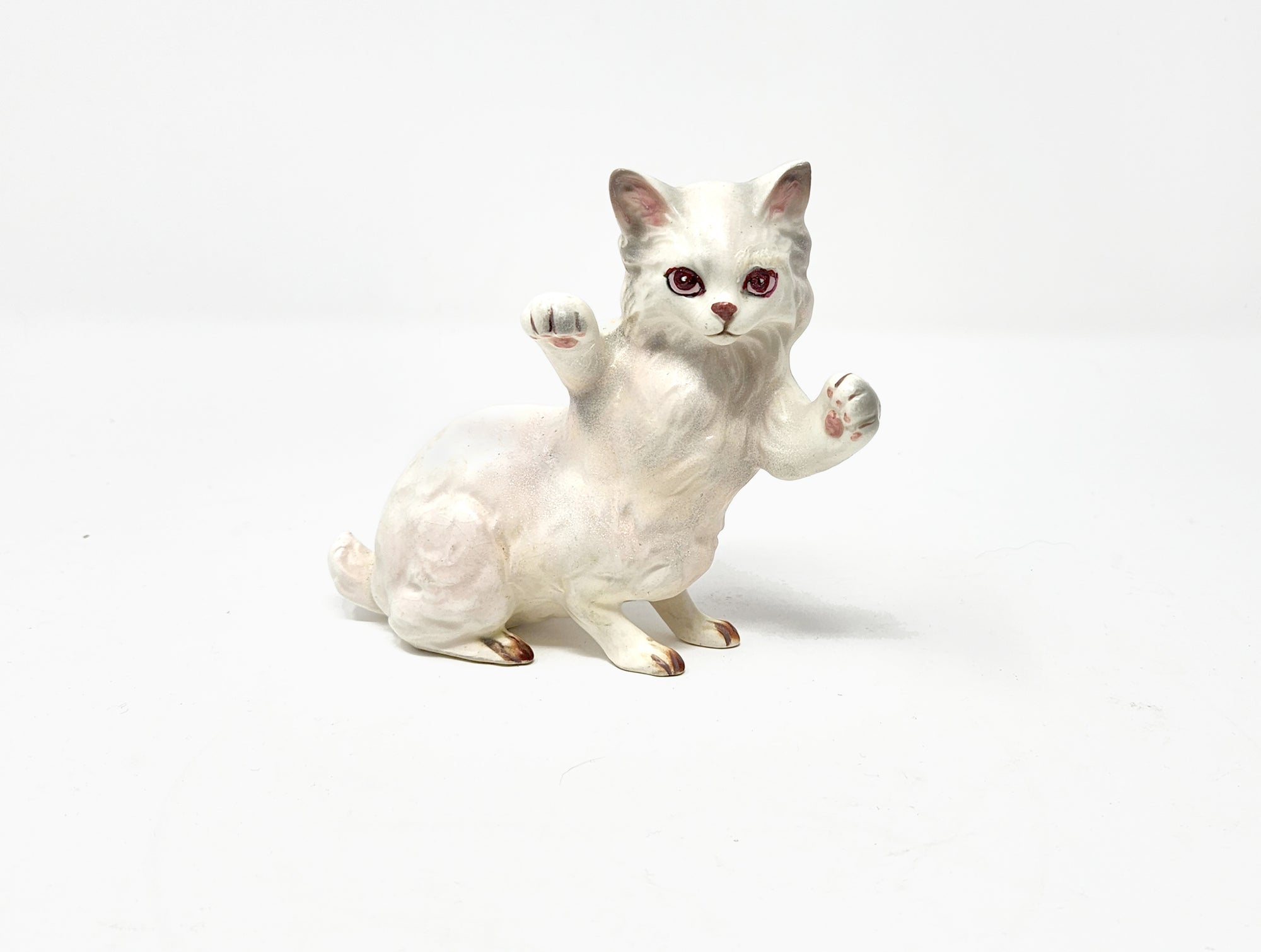 White ceramic cat figurine on a white background