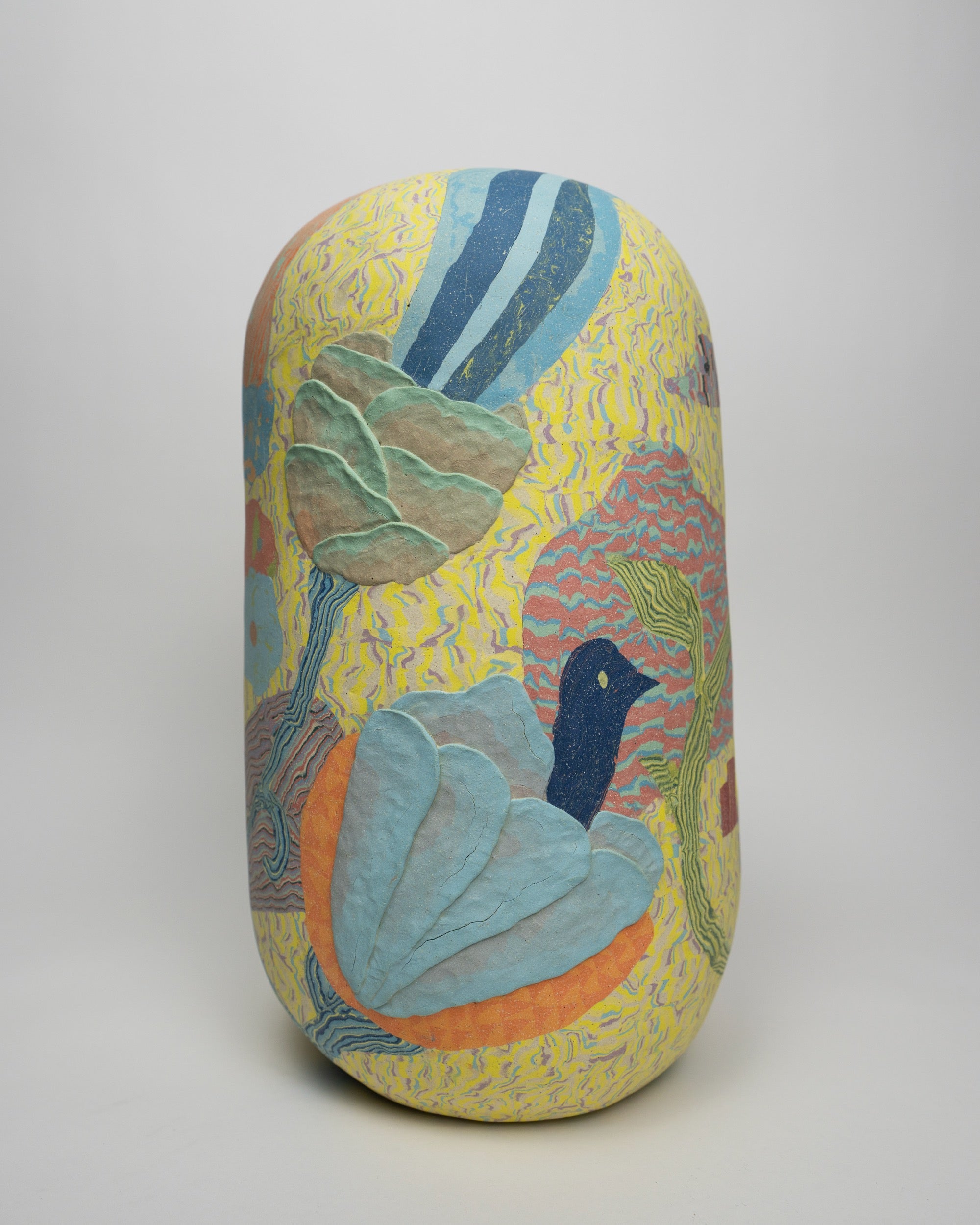 a colorful ovoid vase with flowers and a bird