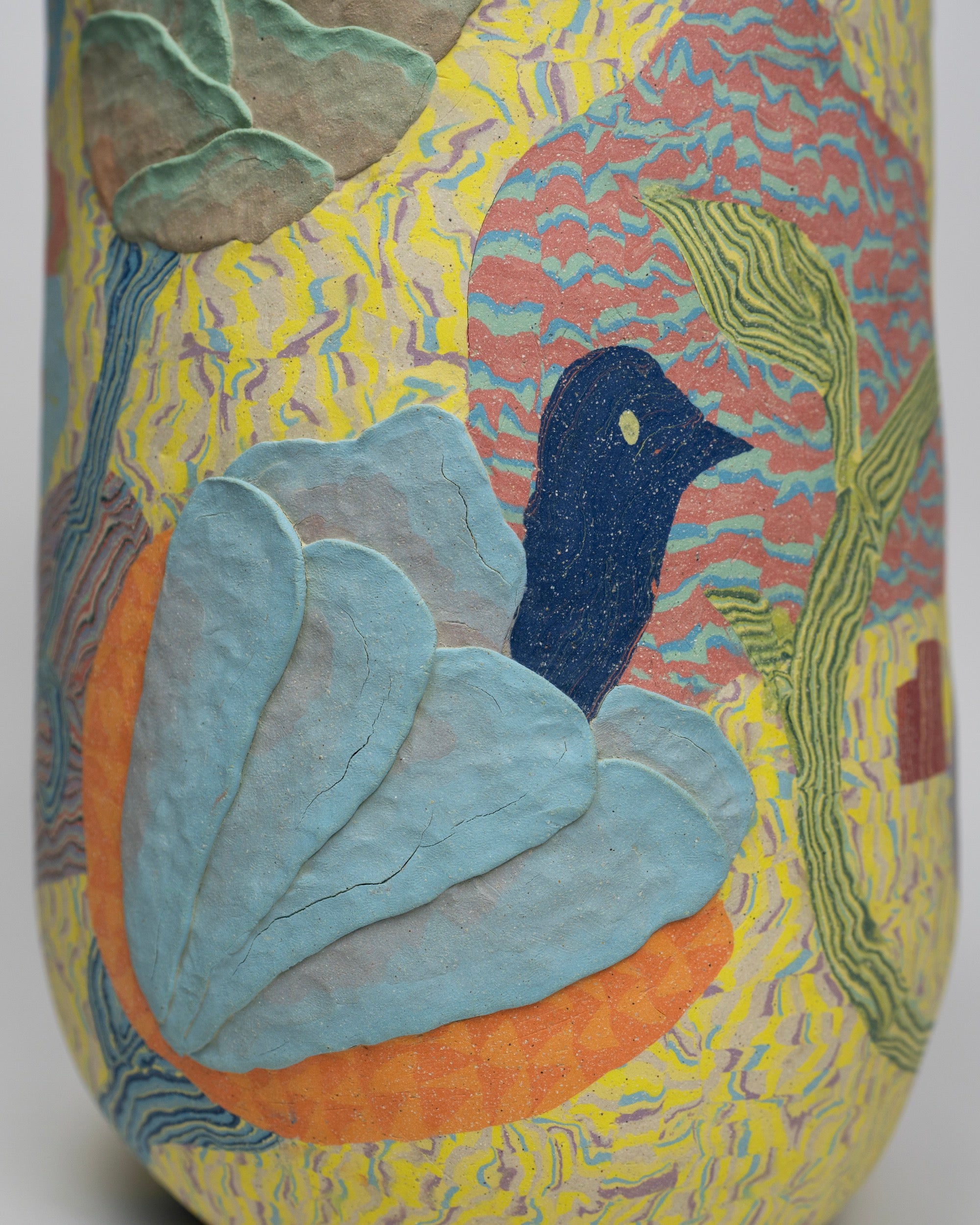 a colorful ovoid vase with flowers and a bird