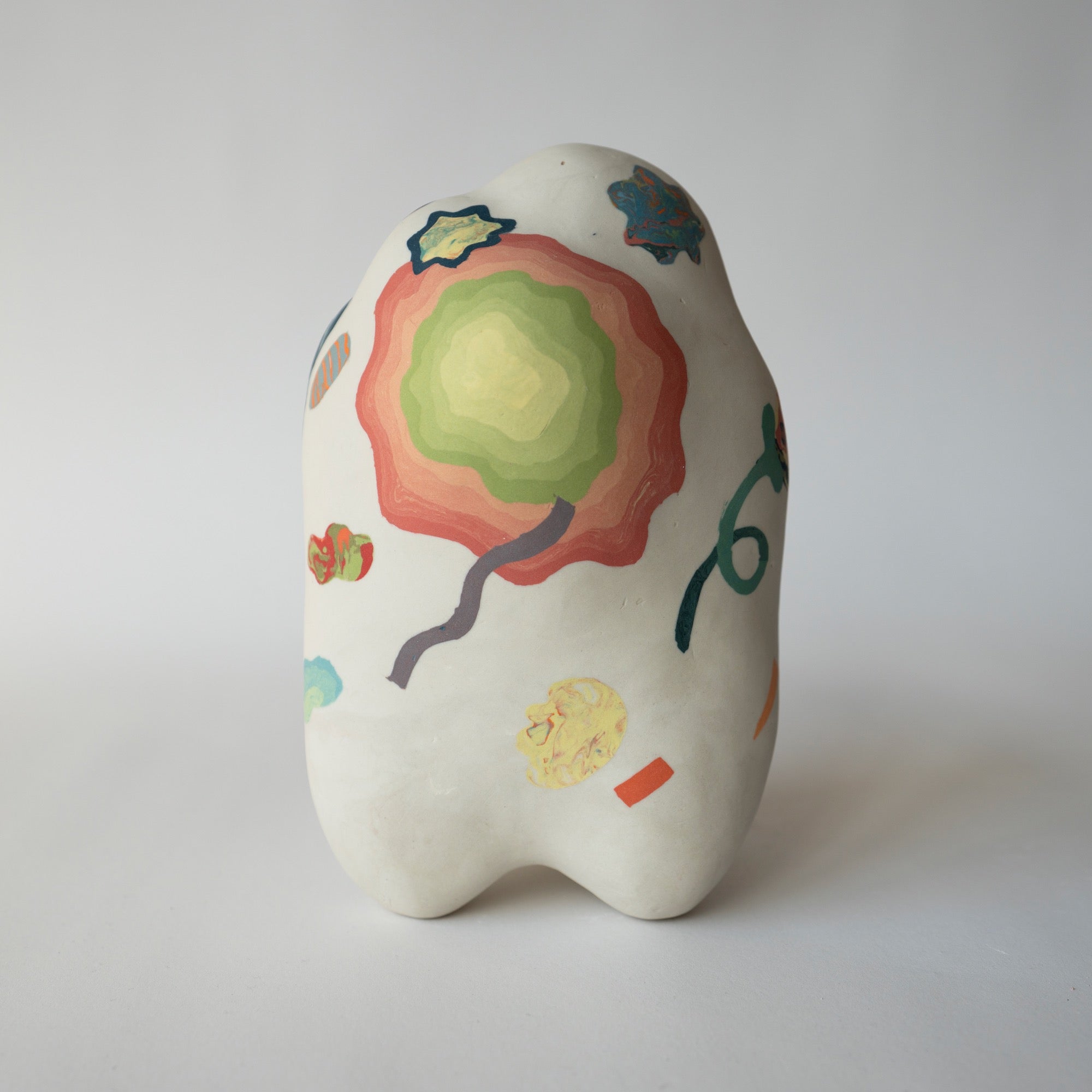 Ceramic piece with colorful abstract designs on a white background
