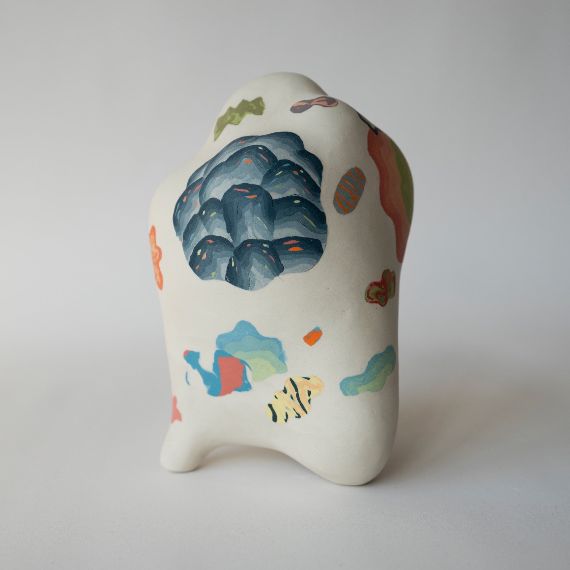 Ceramic piece with colorful abstract designs on a white background