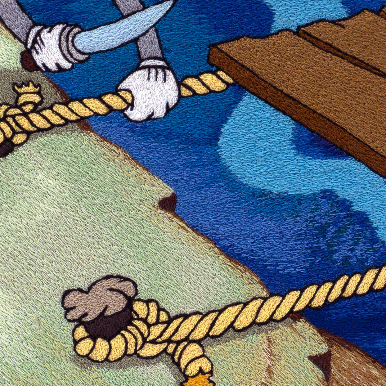 detail of an embroidery of a cartoon figure cutting rope holding a wooden rig to a dock